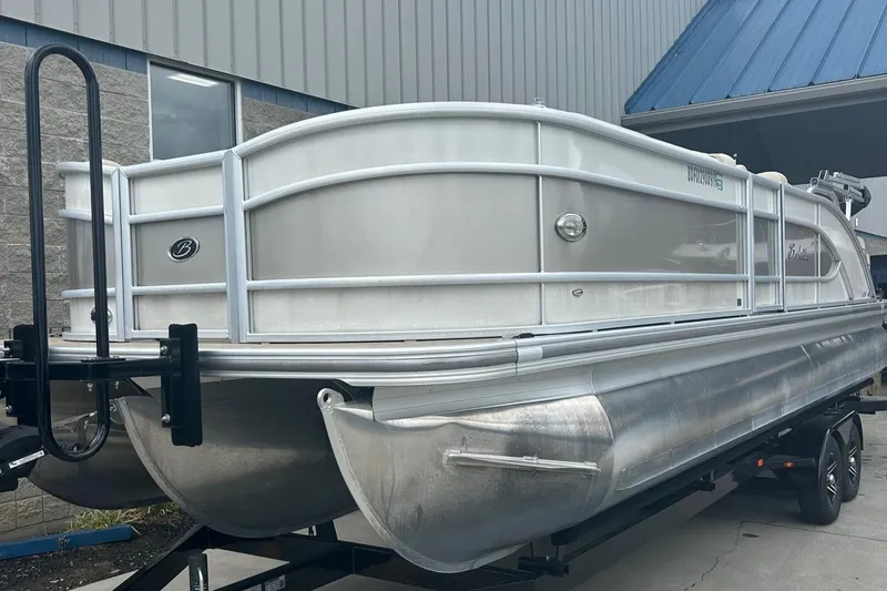 Slide: The Image of 2019 Barletta L25U pontoon boat on trailer, docked outside a building. - 4