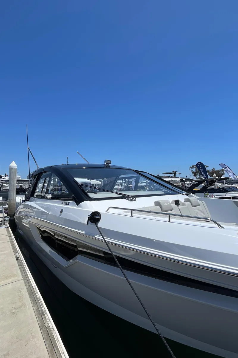 Slide: The Image of 2024 Cruisers Yachts 42GLS docked at marina under clear blue sky. - 3