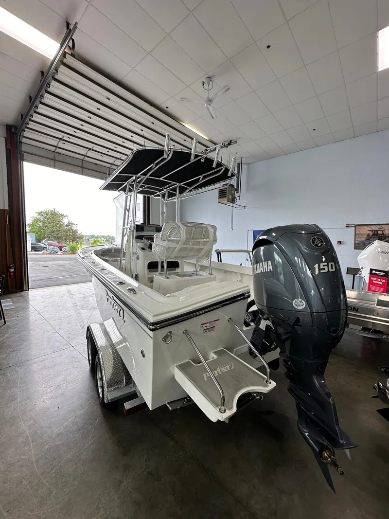 Slide: The Image of 2025 Parker 21SE Center Console boat with Yamaha 150 engine in a showroom. - 2
