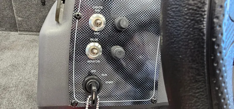 Slide: The Image of 2024 Tracker Bass Tracker Classic XL boat control panel with switches and key ignition. - 9