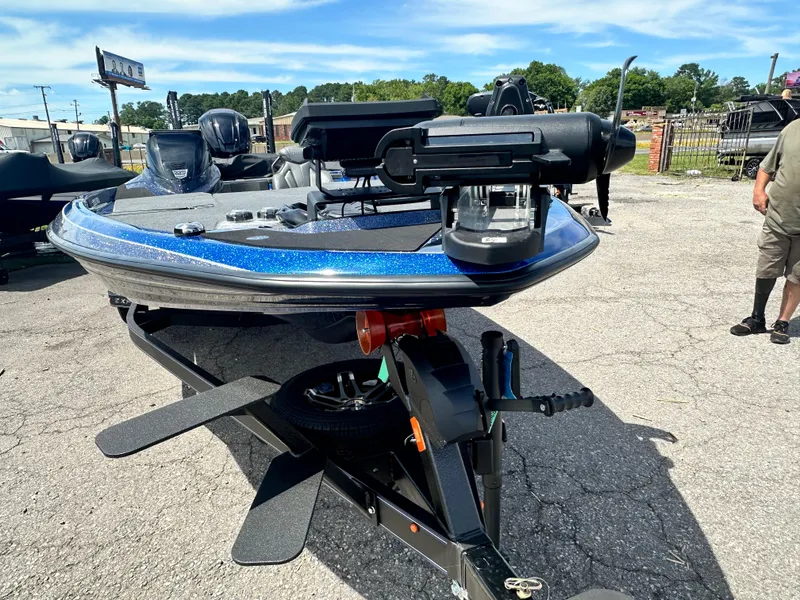 Slide: The Image of 2024 Skeeter ZXR21 bass boat on a trailer in a parking lot. - 10