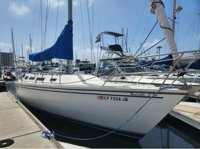 Slide: The Image of 1985 Catalina 36 sailboat docked at marina with blue sail cover. - 1