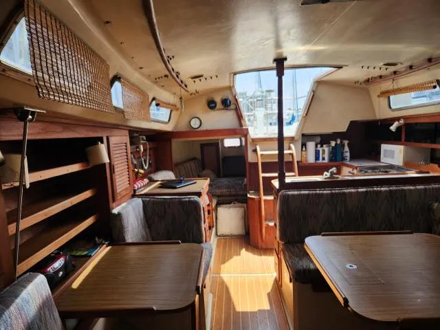 Slide: The Image of Interior of a 1985 Catalina 36 sailboat with wooden furnishings and seating areas. - 10