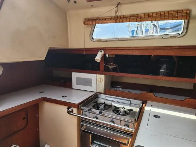 Slide: The Image of 1985 Catalina 36 sailboat kitchen with stove, microwave, and window. - 13