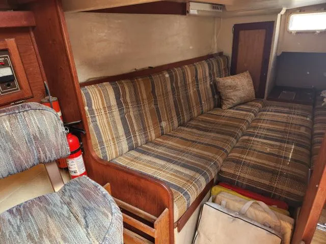 Slide: The Image of Interior of a 1985 Catalina 36 sailboat with plaid seating and wooden accents. - 16