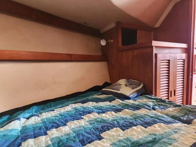 Slide: The Image of Cozy cabin bed in a 1985 Catalina 36 sailboat with a colorful quilt. - 19