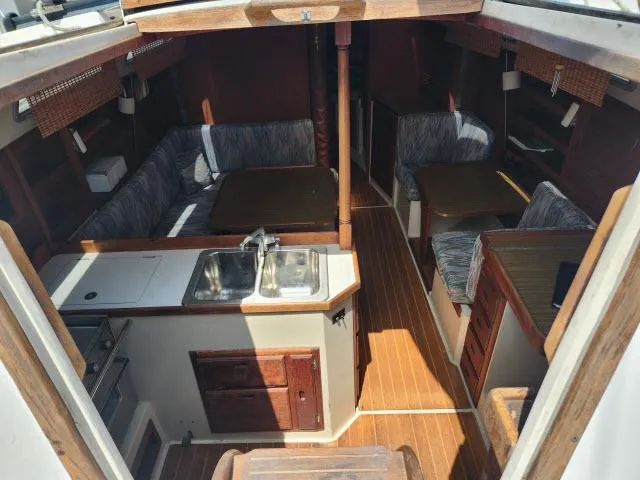 Slide: The Image of Interior of 1985 Catalina 36 sailboat with kitchen, sink, seating, and wooden flooring. - 2