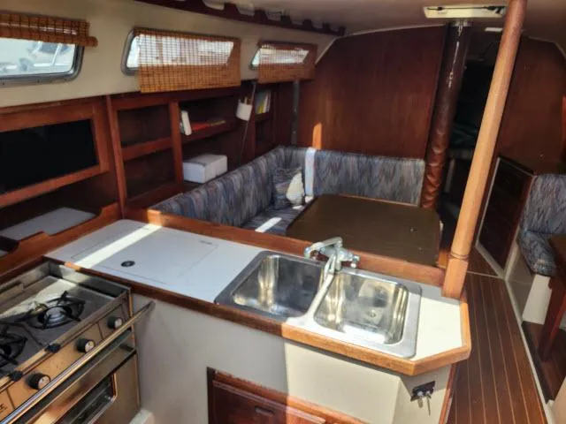 Slide: The Image of Interior of 1985 Catalina 36 sailboat with kitchen, sink, stove, and cozy seating area. - 3