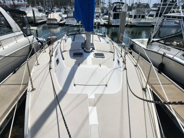 Slide: The Image of 1985 Catalina 36 sailboat docked at a marina, surrounded by other boats. - 34