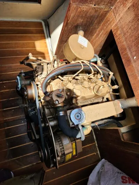 Slide: The Image of 1985 Catalina 36 engine compartment with visible engine components and wooden flooring. - 39