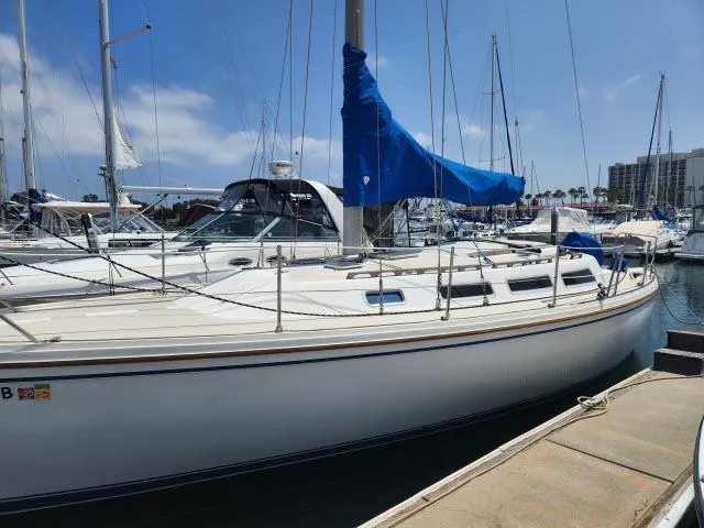 Slide: The Image of 1985 Catalina 36 sailboat docked at a marina on a sunny day. - 41