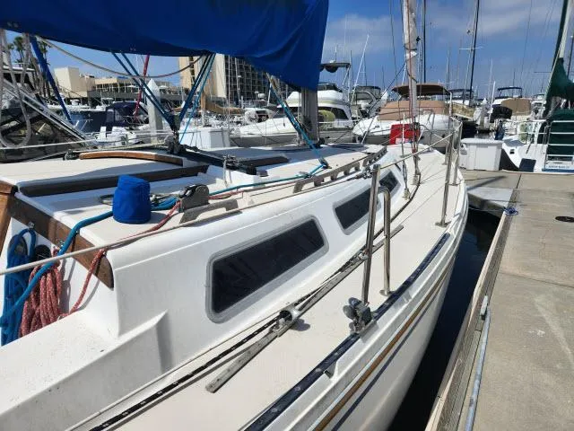 Slide: The Image of 1985 Catalina 36 sailboat docked at marina with blue cover. - 44