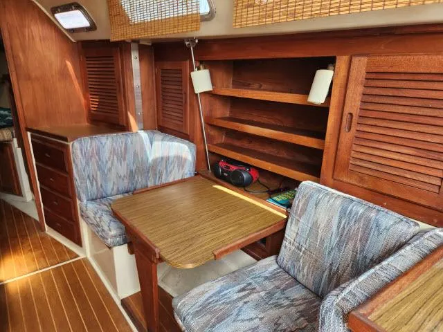 Slide: The Image of Interior of 1985 Catalina 36 sailboat with wooden cabinetry and cozy seating area. - 7