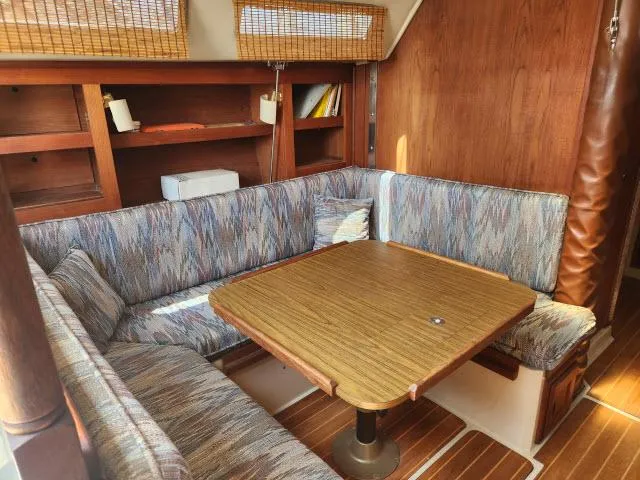 Slide: The Image of Interior of 1985 Catalina 36 sailboat with cozy dining area and wooden table. - 8