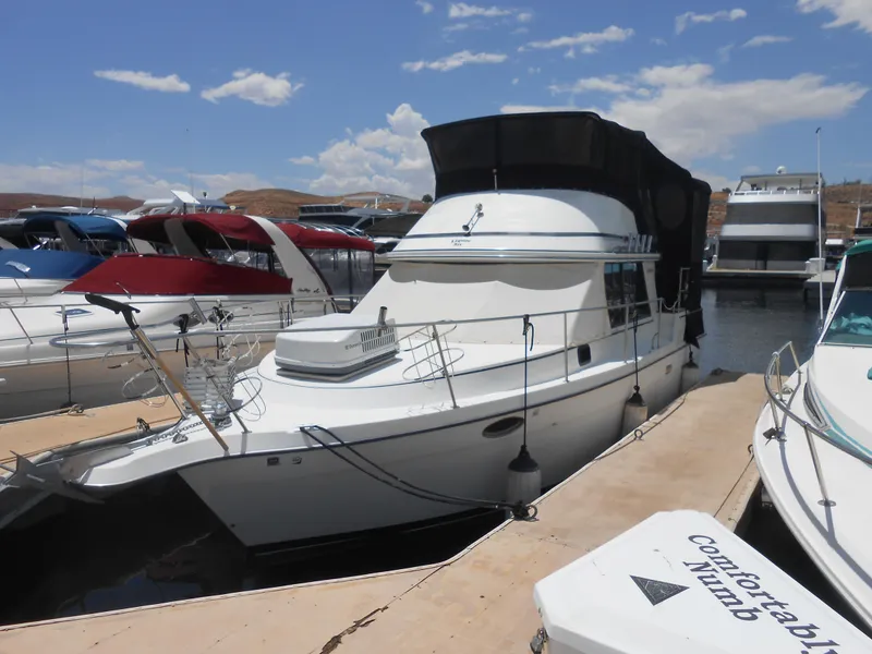 Slide: The Image of 1989 Cooper Marine Prowler 9m docked at a marina under a clear sky. - 1