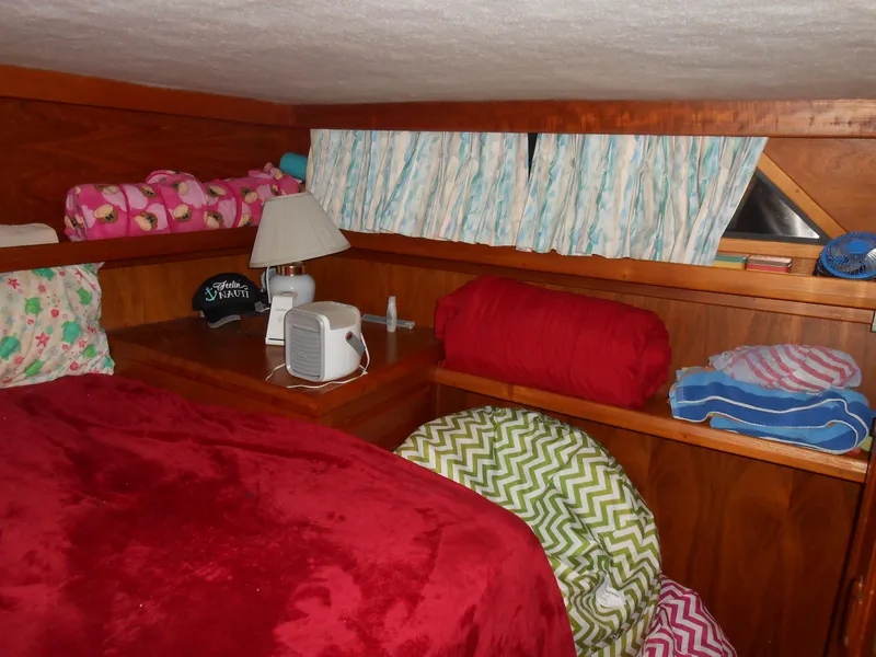 Slide: The Image of Cozy cabin interior of 1989 Cooper Marine Prowler 9m with red bedding and wooden shelves. - 10