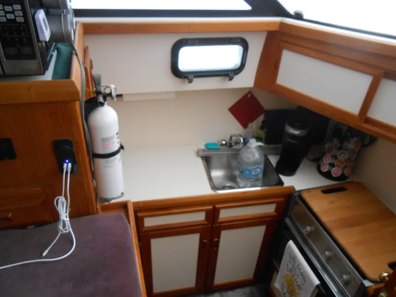 Slide: The Image of Compact kitchen area in a 1989 Cooper Marine Prowler 9m boat. - 11