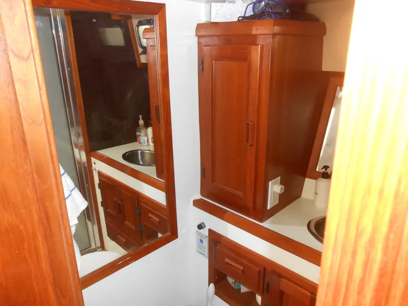Slide: The Image of 1989 Cooper Marine Prowler 9m boat bathroom with wooden cabinets and mirror. - 13