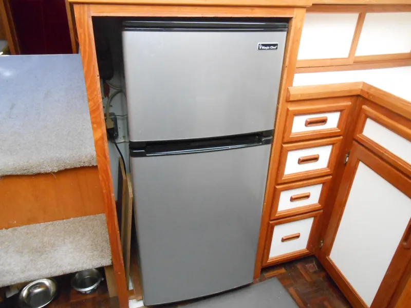 Slide: The Image of Compact refrigerator in the kitchen area of a 1989 Cooper Marine Prowler 9m boat. - 16