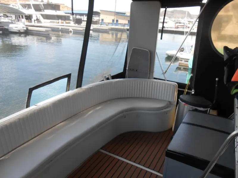 Slide: The Image of Interior of 1989 Cooper Marine Prowler 9m boat with white seating and wooden flooring. - 4