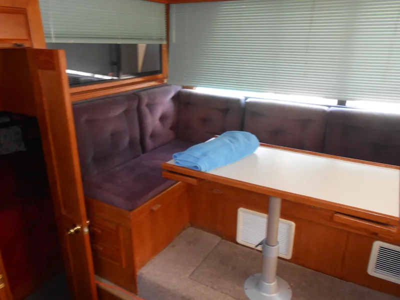 Slide: The Image of Interior seating area of 1989 Cooper Marine Prowler 9m boat with table and blinds. - 7