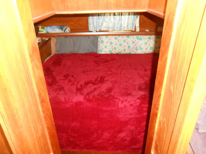 Slide: The Image of Cozy sleeping quarters in 1989 Cooper Marine Prowler 9m boat with red bedding. - 8