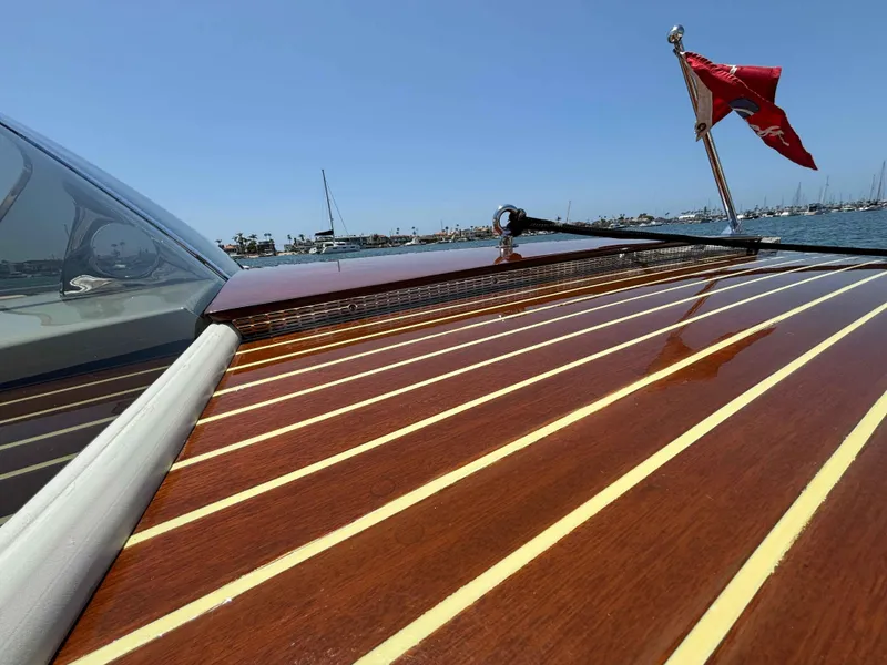Slide: The Image of 1960 Chris-Craft Continental Gull Wing boat with polished wooden deck and red flag on a sunny day. - 12