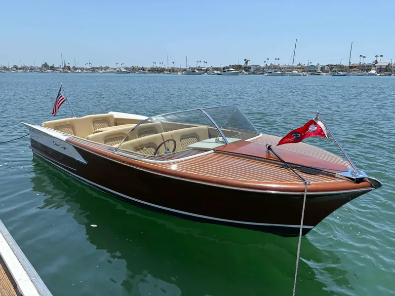 Slide: The Image of 1960 Chris-Craft Continental Gull Wing boat on calm water, featuring classic wooden design. - 2