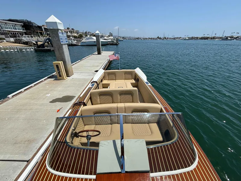 Slide: The Image of 1960 Chris-Craft Continental Gull Wing boat docked at a marina, featuring classic wooden design. - 3