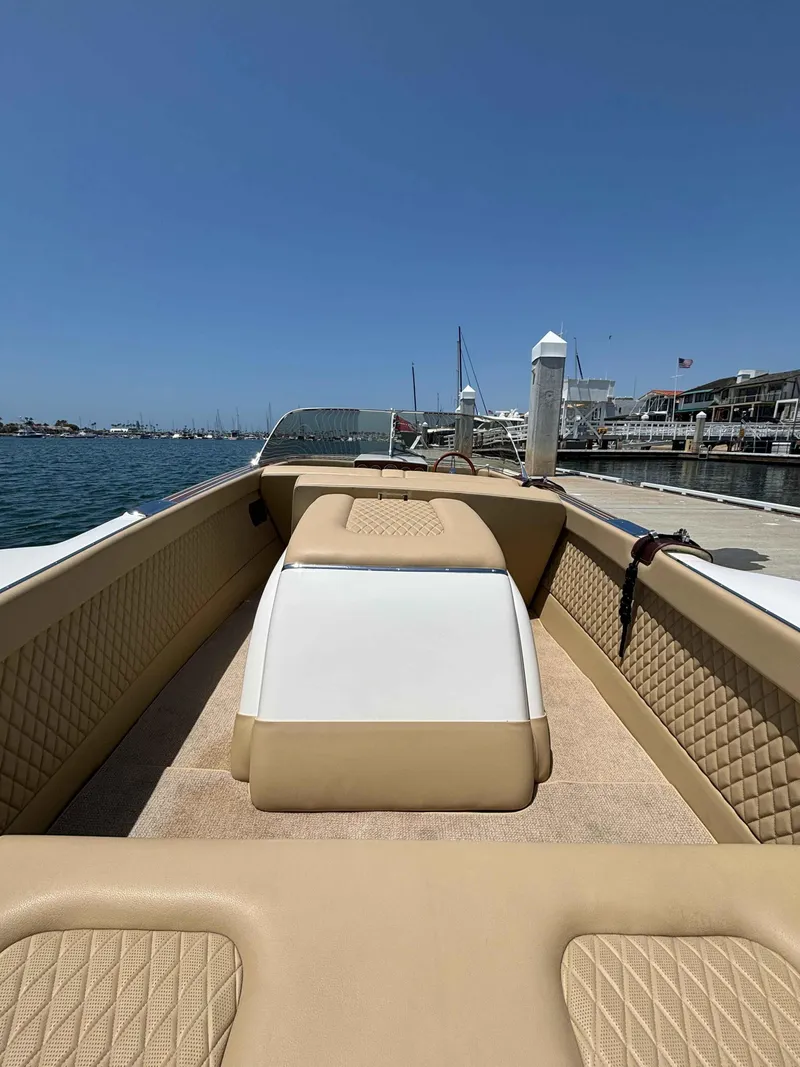 Slide: The Image of 1960 Chris-Craft Continental Gull Wing boat interior with tan upholstery, docked by the water. - 7
