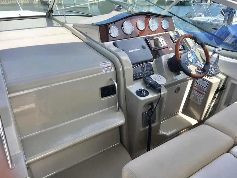 Slide: The Image of Helm of 2010 Sea Ray 330 Sundancer with modern controls and wood-accented dashboard. - 10
