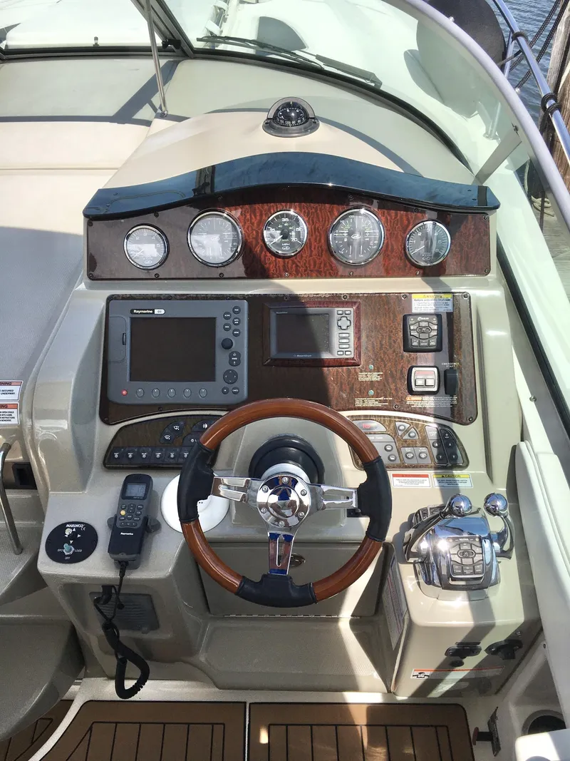 Slide: The Image of Helm of 2010 Sea Ray 330 Sundancer with wood accents and modern navigation equipment. - 11