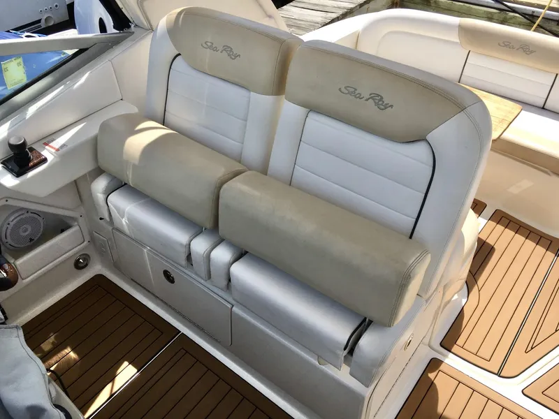 Slide: The Image of 2010 Sea Ray 330 Sundancer cockpit seating with beige and white upholstery. - 15