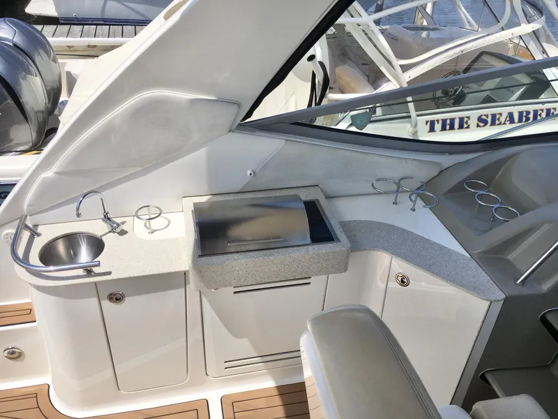 Slide: The Image of 2010 Sea Ray 330 Sundancer cockpit with sink, grill, and cup holders. - 18