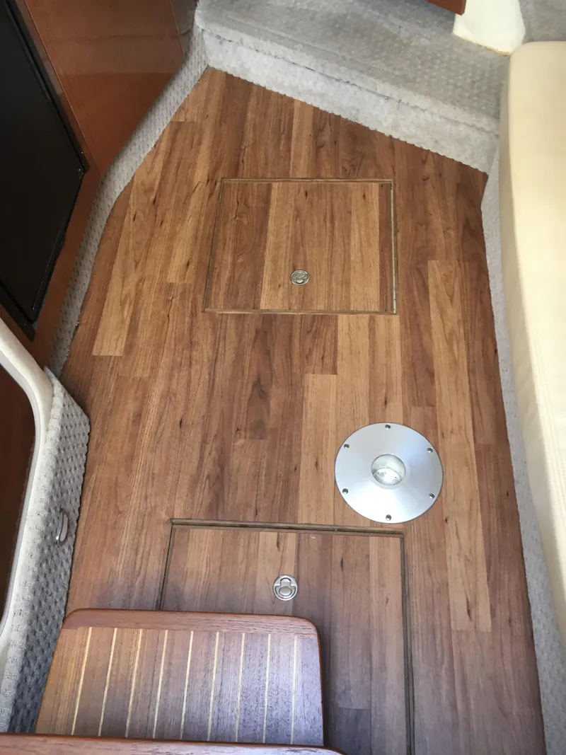 Slide: The Image of 2010 Sea Ray 330 Sundancer interior with wood flooring and hatch. - 21