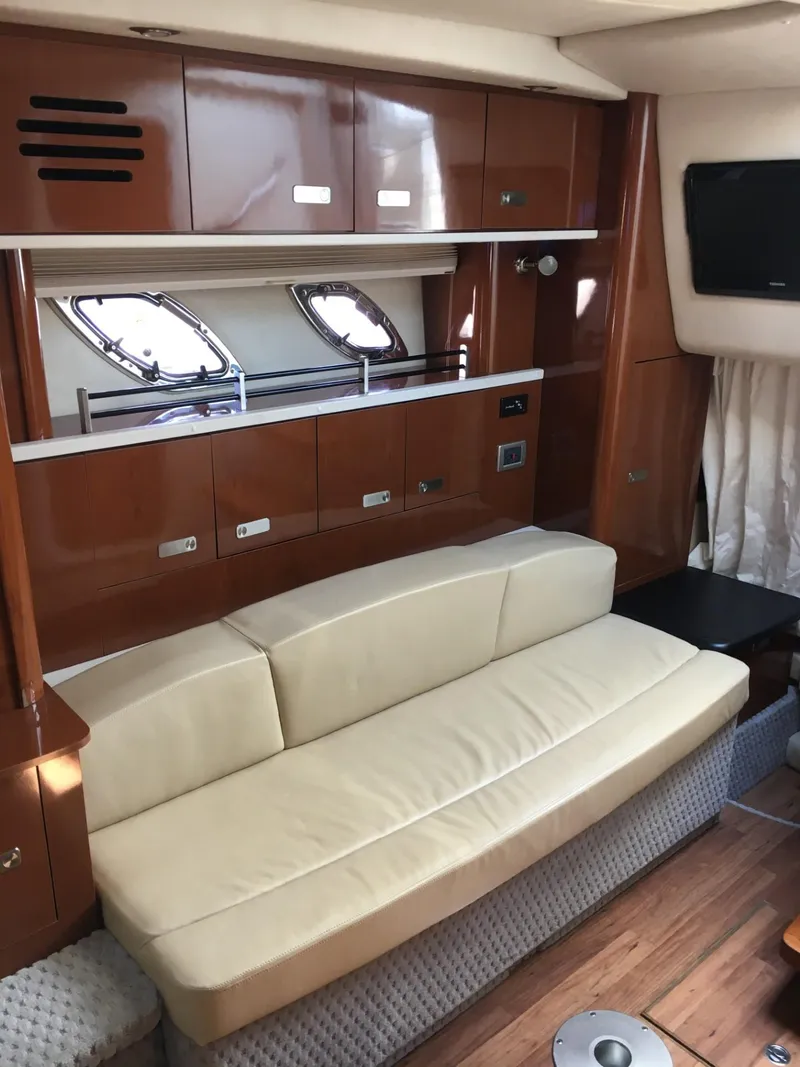 Slide: The Image of Interior of 2010 Sea Ray 330 Sundancer with beige sofa and wooden cabinetry. - 26