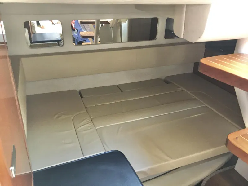 Slide: The Image of Interior cabin of 2010 Sea Ray 330 Sundancer with beige seating and wooden table. - 27