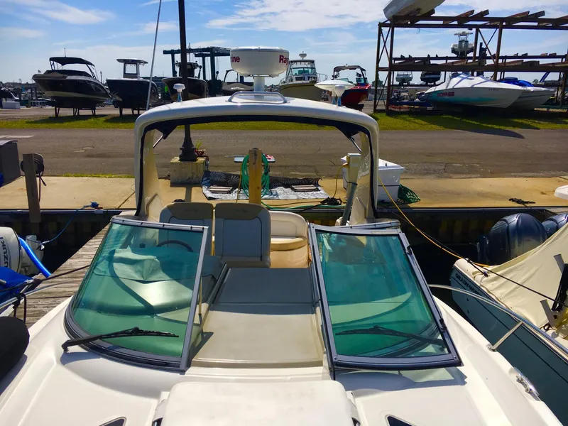Slide: The Image of 2010 Sea Ray 330 Sundancer docked at marina, showcasing open cockpit and windshield. - 5