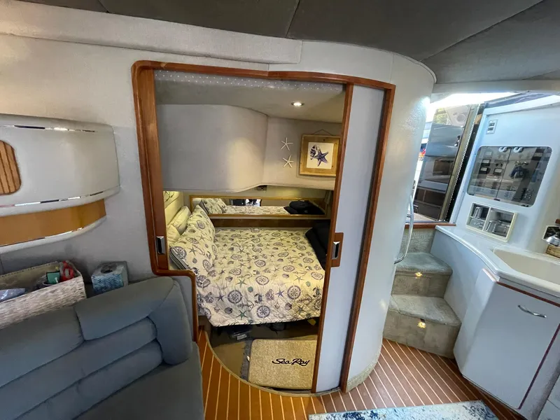 Slide: The Image of 1989 Sea Ray 420 interior with cozy bedroom, wooden accents, and modern amenities. - 26