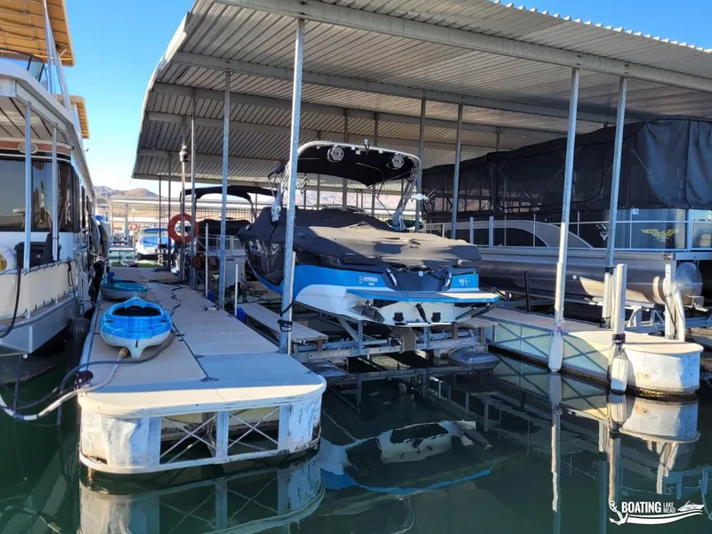 Slide: The Image of 2018 MasterCraft XT 22 boat docked in a covered marina slip. - 15