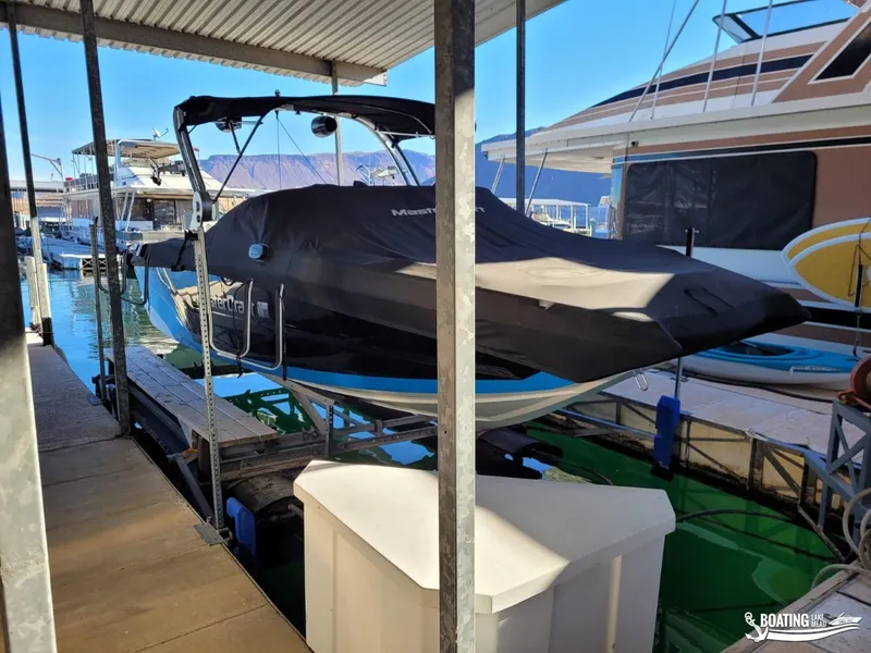 Slide: The Image of 2018 MasterCraft XT 22 boat docked under a covered marina. - 17