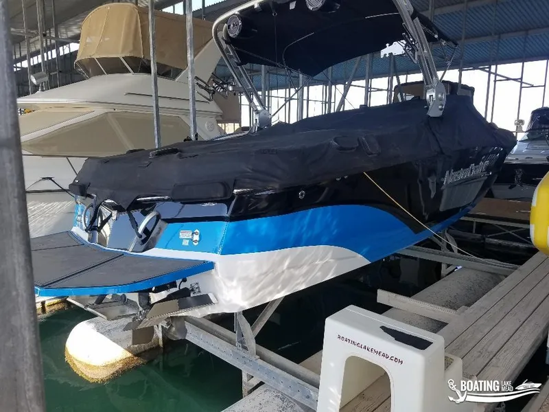 Slide: The Image of 2018 MasterCraft XT 22 boat docked at marina, covered and ready for use. - 2