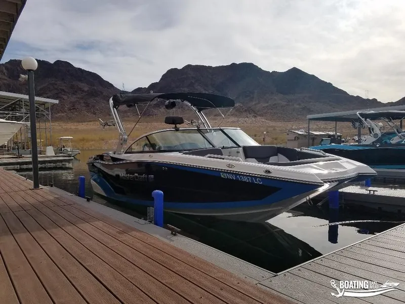 Slide: The Image of 2018 MasterCraft XT 22 boat docked at a marina with mountains in the background. - 3