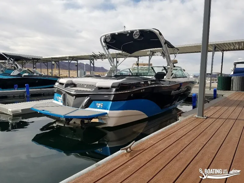 Slide: The Image of 2018 MasterCraft XT 22 boat docked at a marina on a cloudy day. - 5
