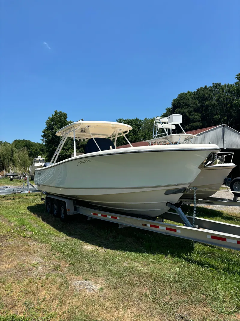 Slide: The Image of 2008 Pursuit S 310 Sport boat on a trailer in a grassy area. - 1