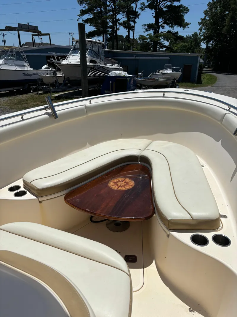 Slide: The Image of 2008 Pursuit S 310 Sport boat with cushioned seating and wooden table. - 10
