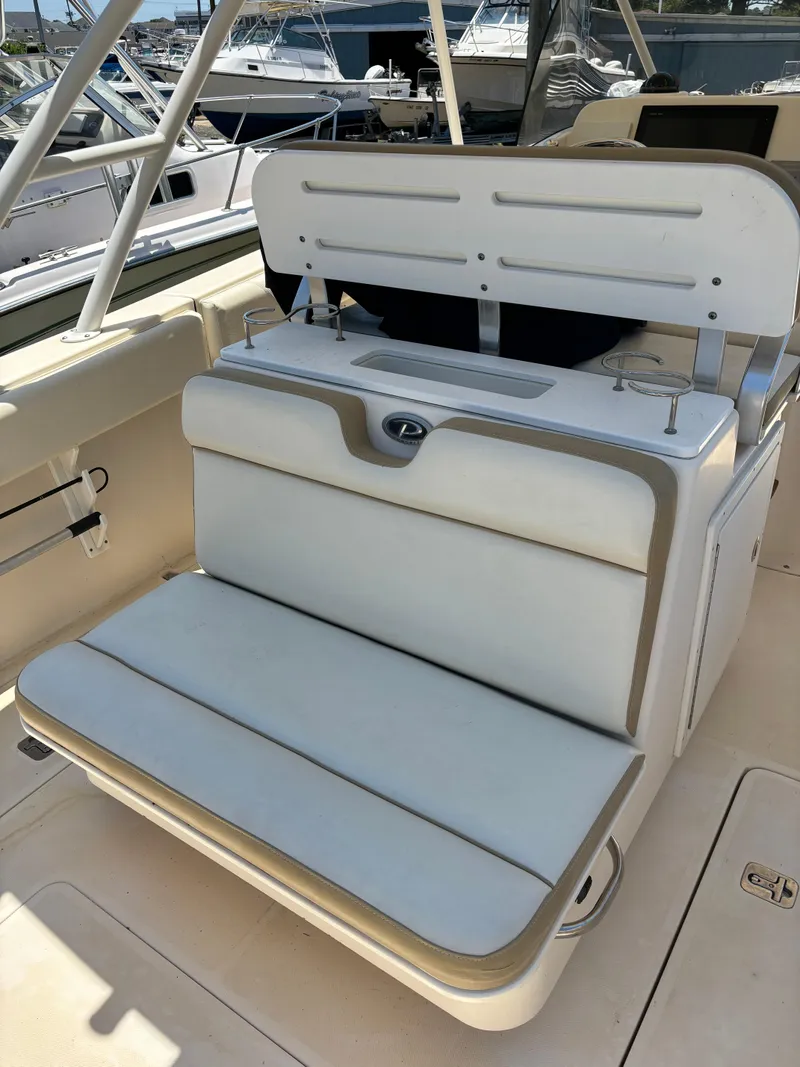 Slide: The Image of 2008 Pursuit S 310 Sport boat seating area with white cushioned bench. - 12