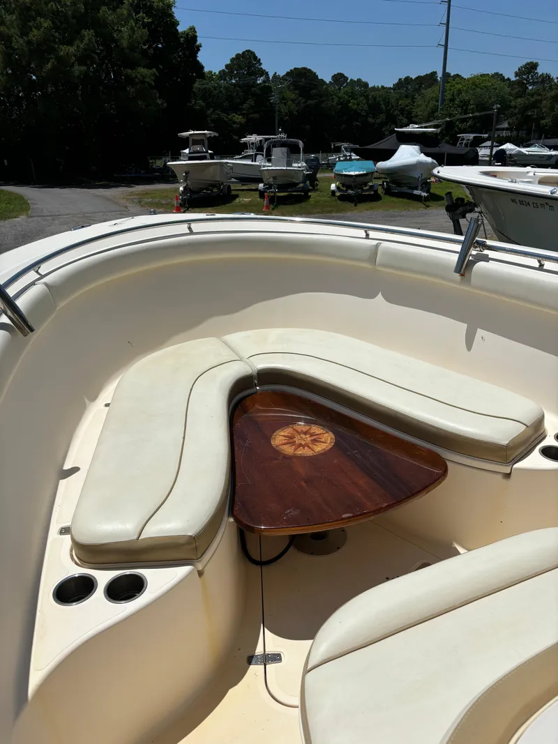 Slide: The Image of 2008 Pursuit S 310 Sport boat with cushioned seating and wooden table. - 13