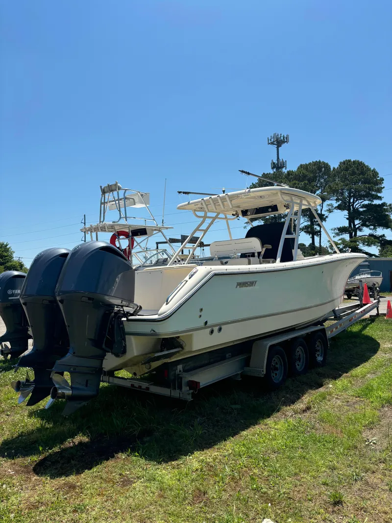 Slide: The Image of 2008 Pursuit S 310 Sport boat on a trailer with twin outboard engines. - 2
