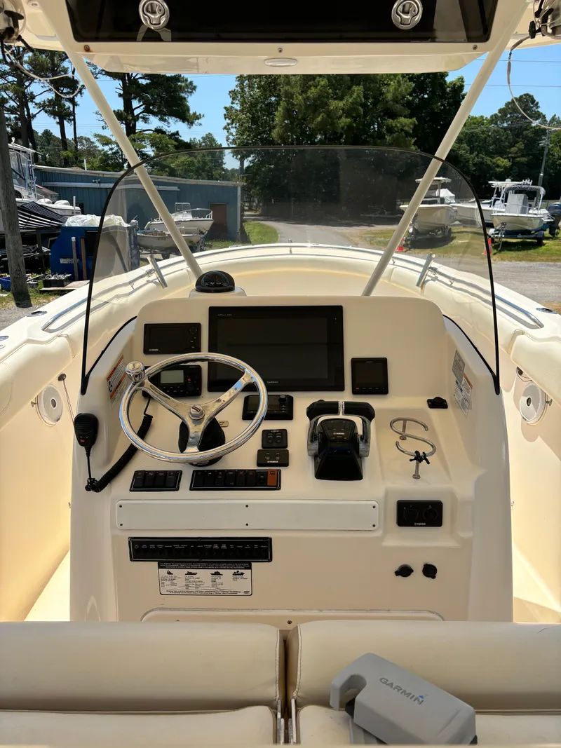 Slide: The Image of 2008 Pursuit S 310 Sport boat dashboard with steering wheel and navigation controls. - 8